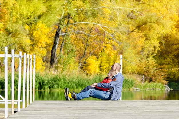 Father and son are sitting on the dock