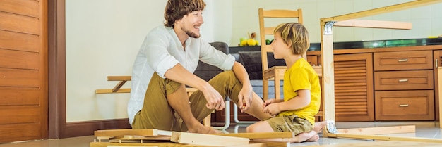 父と息子が家で彼のお父さんを助ける家具の男の子を組み立てる幸せな家族のコンセプトバナー長い