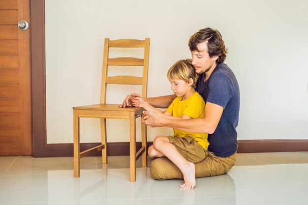 Father and son assembling furniture Boy helping his dad at home Happy Family concept