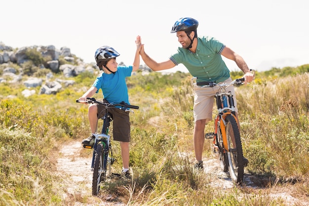 Father and son biking through mountains