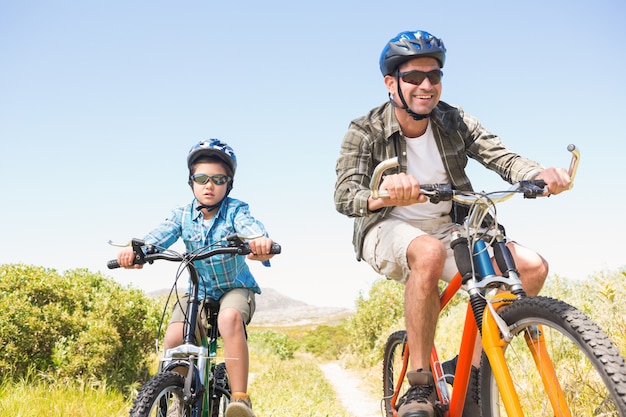 Father and son biking through mountains