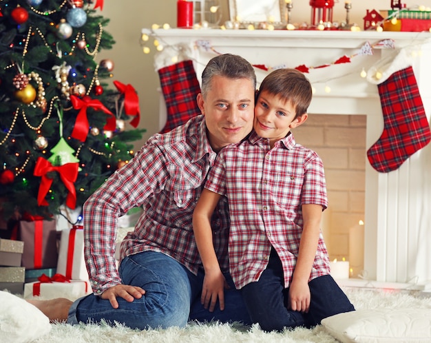 Father and son on Christmas interior background