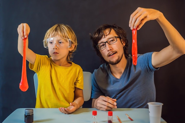 Father and son conduct chemical experiments at home Home made slime Family plays with a slime