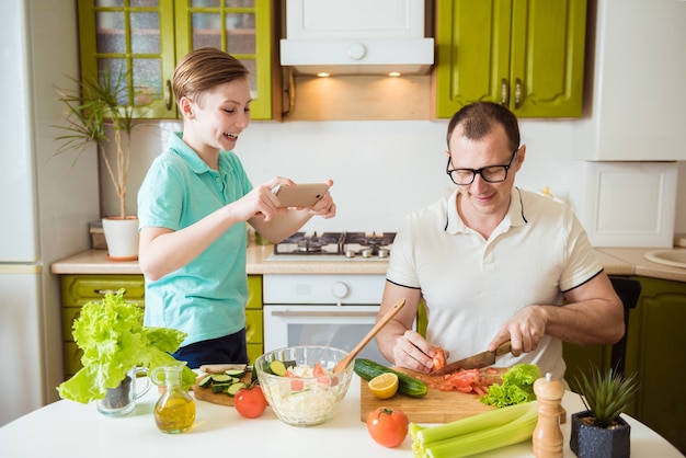 Father and son cooking food together in kitchen