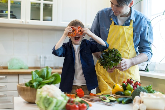 Padre e figlio che cucinano insalata