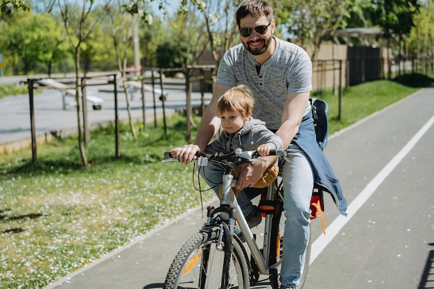 Father and son cycling together on one bicycle