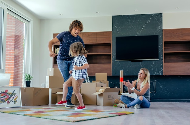 Father and son dancing with the mother looking at them while they take a break from preparing the move