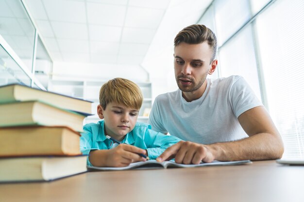 The father and a son doing homework at the table