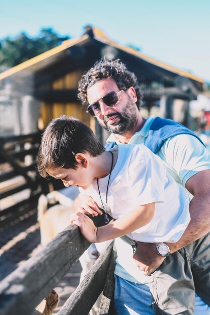 Foto padre e figlio che si godono una giornata di sole in una fattoria.