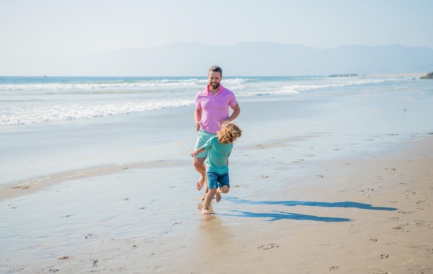 Father and son family running on summer beach family sport