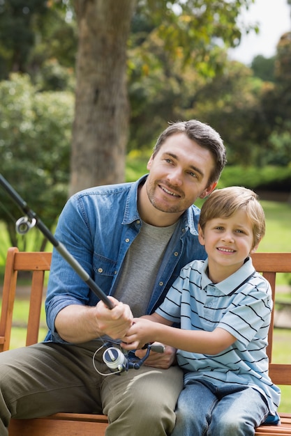 Father and son fishing on park bench