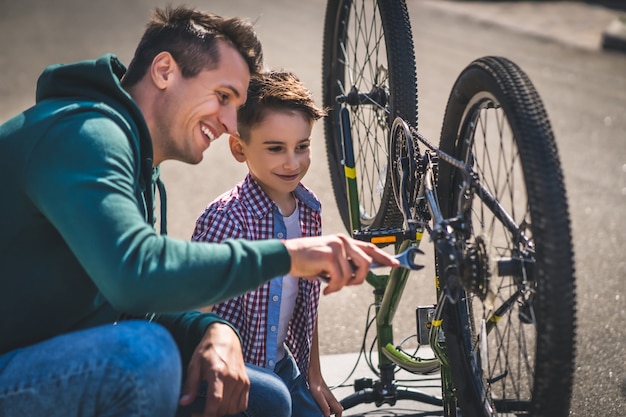 The father and son fixing the bicycle