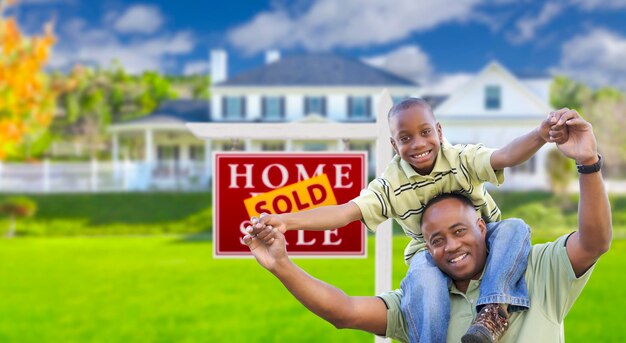 Photo father and son in front of real estate sign and home