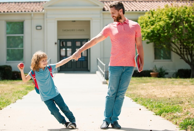 Father and son go to school education and learning parent and pupil of primary school schoolboy with