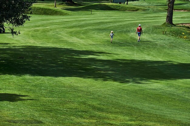 Photo father and son on golf course