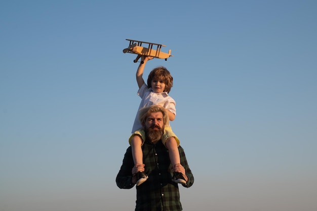 Father and son happy family. Father carrying his son on shoulders.