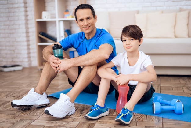 Father and son have a rest after exercising.