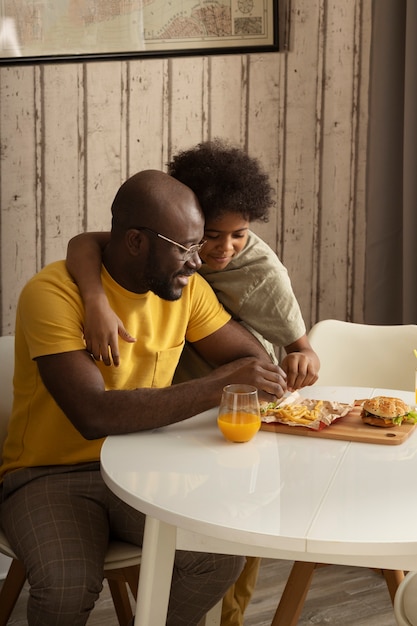 Father and son having french fries and burgers together