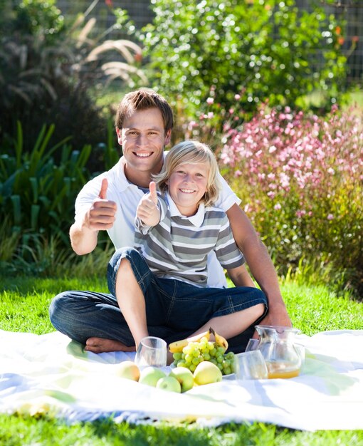 Father and son having a picinic with thumbs up