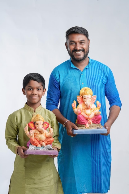 Father and son holding an idol of lord Ganesha