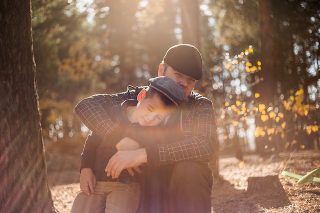 Father and son hugging in autumn park, shallow depth of field. Active family vacation