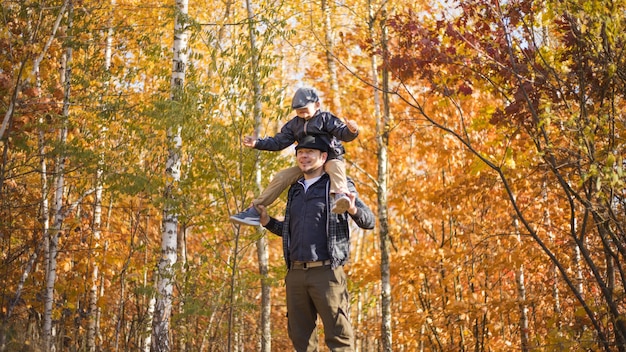 Father and son hugging in autumn park shallow depth of field Active family vacation