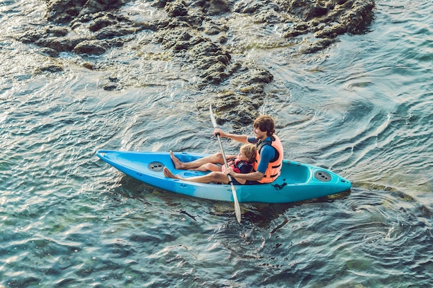 Father and son kayaking at tropical ocean