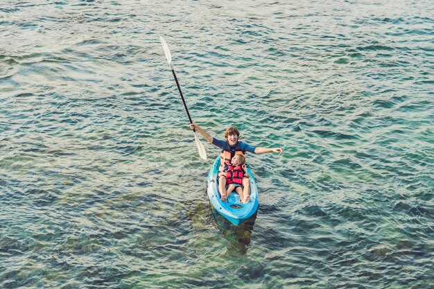 Father and son kayaking at tropical ocean