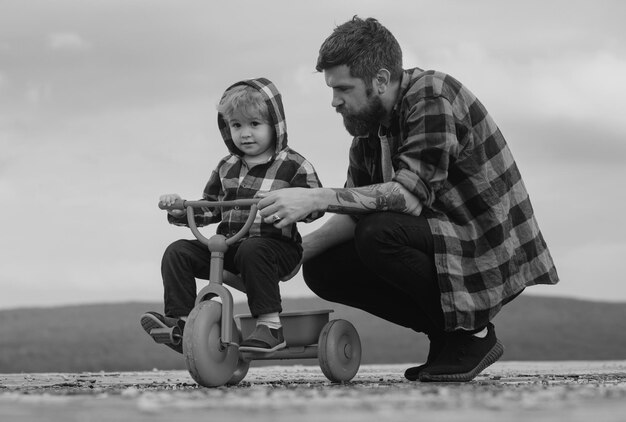 Father and son learning to ride a bicycle little boy learn to ride a bike with his daddy dad teachin