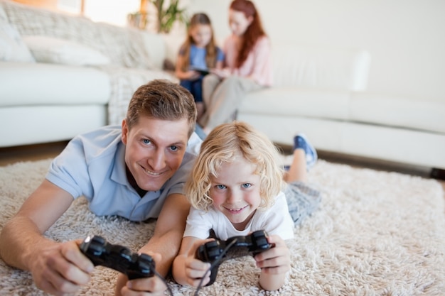 Отец и сын в гостиной играют в видеоигры