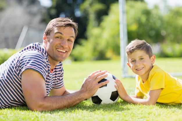 Father and son lying on grass in the park on a sunny day