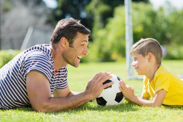 Father and son lying on grass in the park