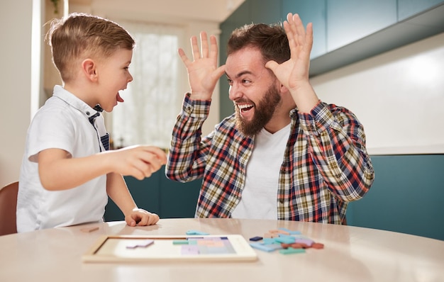 Father and son making funny faces at home