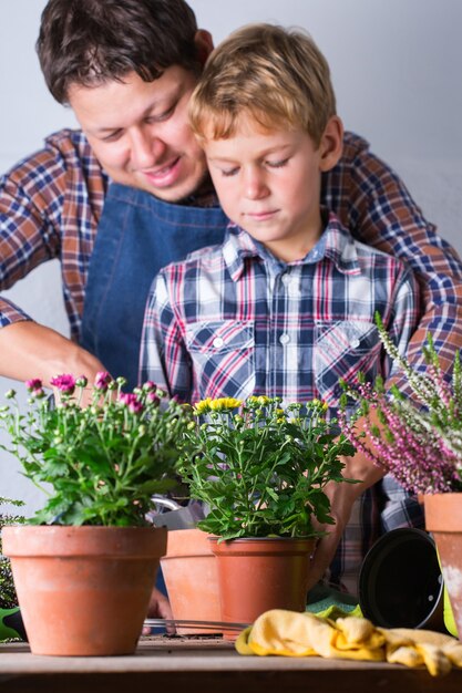 Father and son making urban garden at home. Activity stimulating mental and brain health. Planting and growing autumn flowers, eco-friendly hobby and leisure, family time concept.