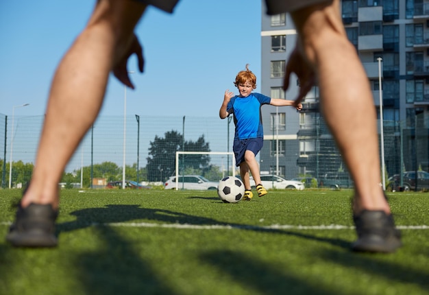 Father and son organizing family football summer camp at city stadium