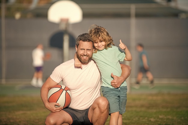 Father and son outdoor happy fathers day family portrait dad and kid boy hold sport ball