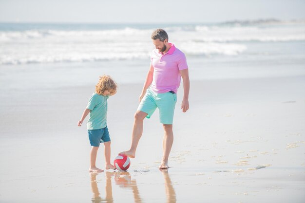 아버지와 아들은 공 축구와 함께 여름 해변에서 축구를 한다