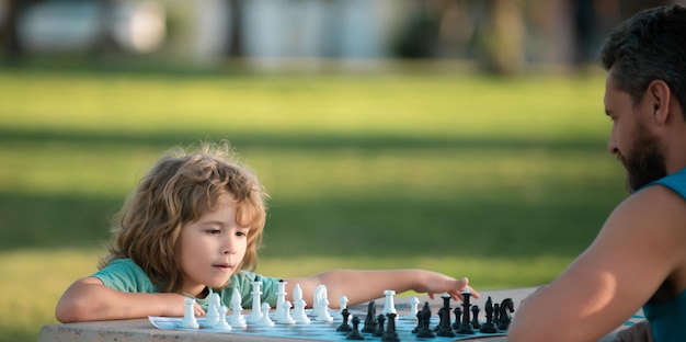 Father and son playing chess spending time together outdoor games and activities for children