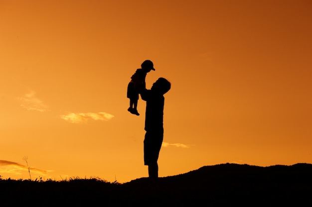 A father and son playing outdoors at sunset