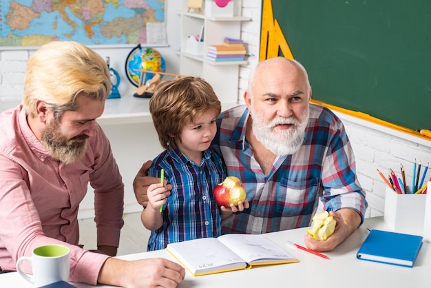 Отец и сын, играя в школьном классе, учатся писать и читать счастливый улыбающийся внук с папой