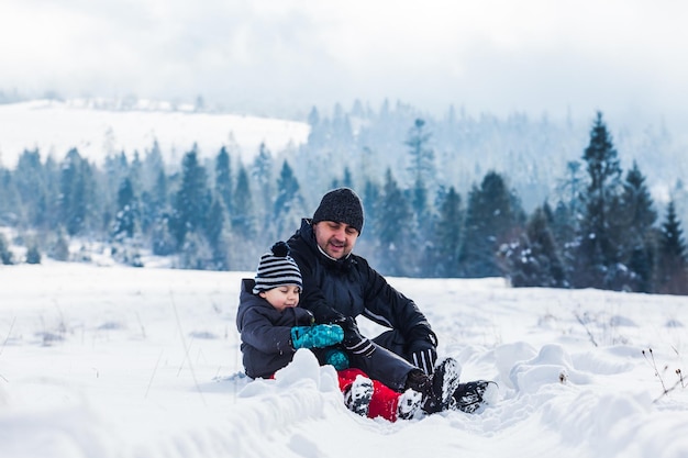 Father and son playing with snow at nature during winter holidays