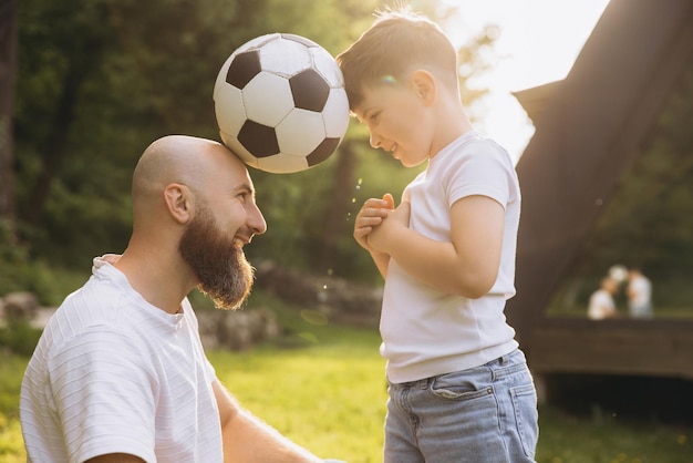 Father and son playing with soccer ball celebrating fathers day