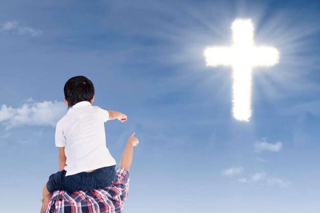 Father and son pointing at cross