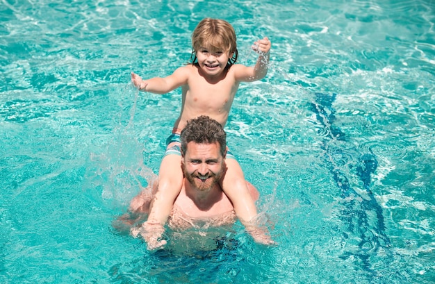 プールで遊ぶ父と息子家族の夏休みプールパーティーパパとプールでプレーする少年