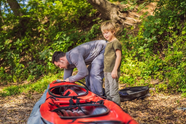 Father and son prepare a kayak for rowing on the sea