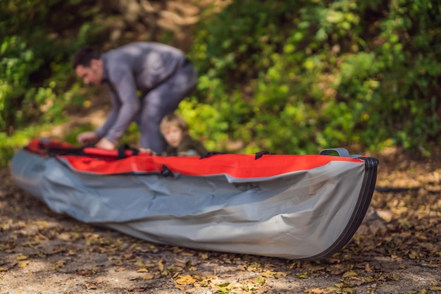 Father and son prepare a kayak for rowing on the sea