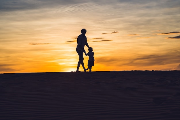 Photo father and son at the red desert at dawn