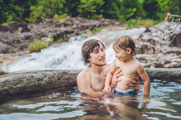 Father and son relaxing in hot spring pool