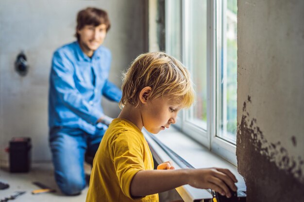 父と息子は一緒に窓を修理します。自分で家を修理してください。