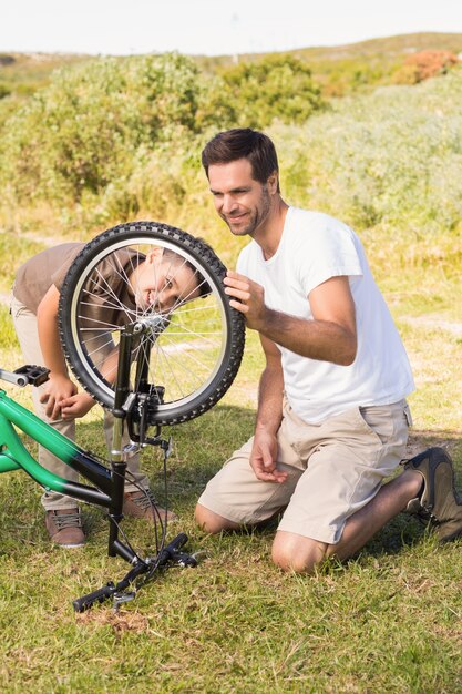 Father and son repairing bike together